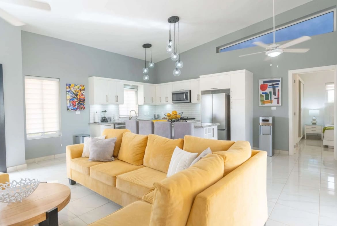 Villa Sunseeker Casa Linda: Yellow sofa in open-plan living area with kitchen.