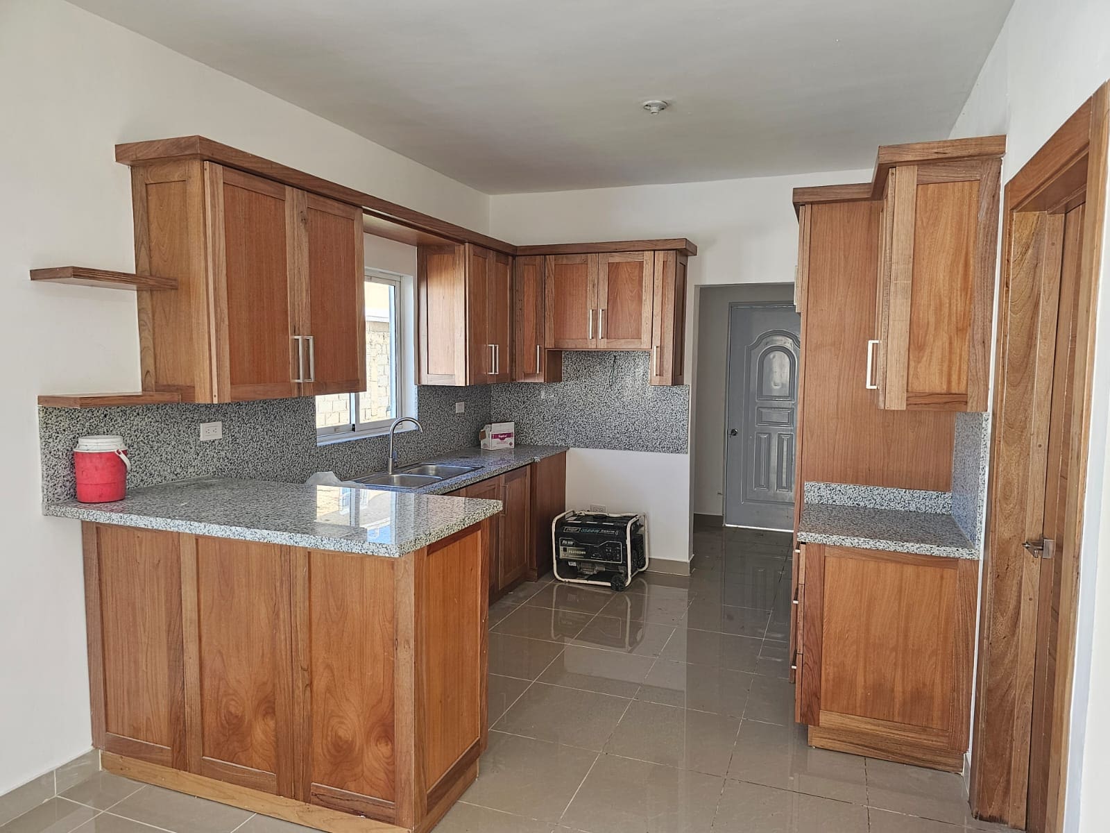 Wood kitchen cabinets and granite countertops in a modern kitchen.
