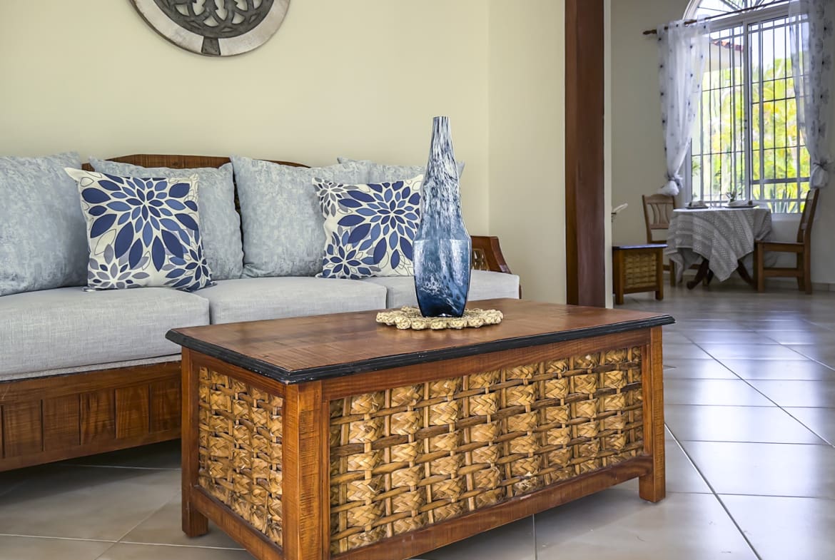 Living room with wooden furniture, blue pillows, and decorative vase