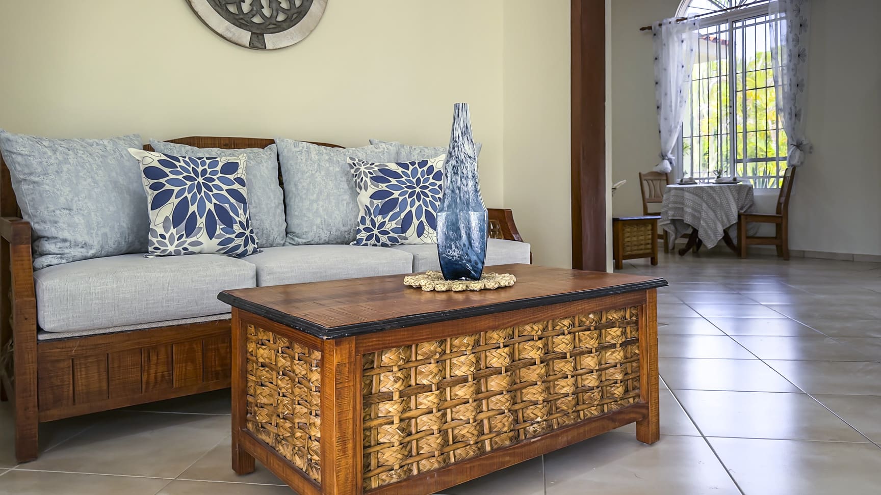 Living room with wooden furniture, blue pillows, and decorative vase