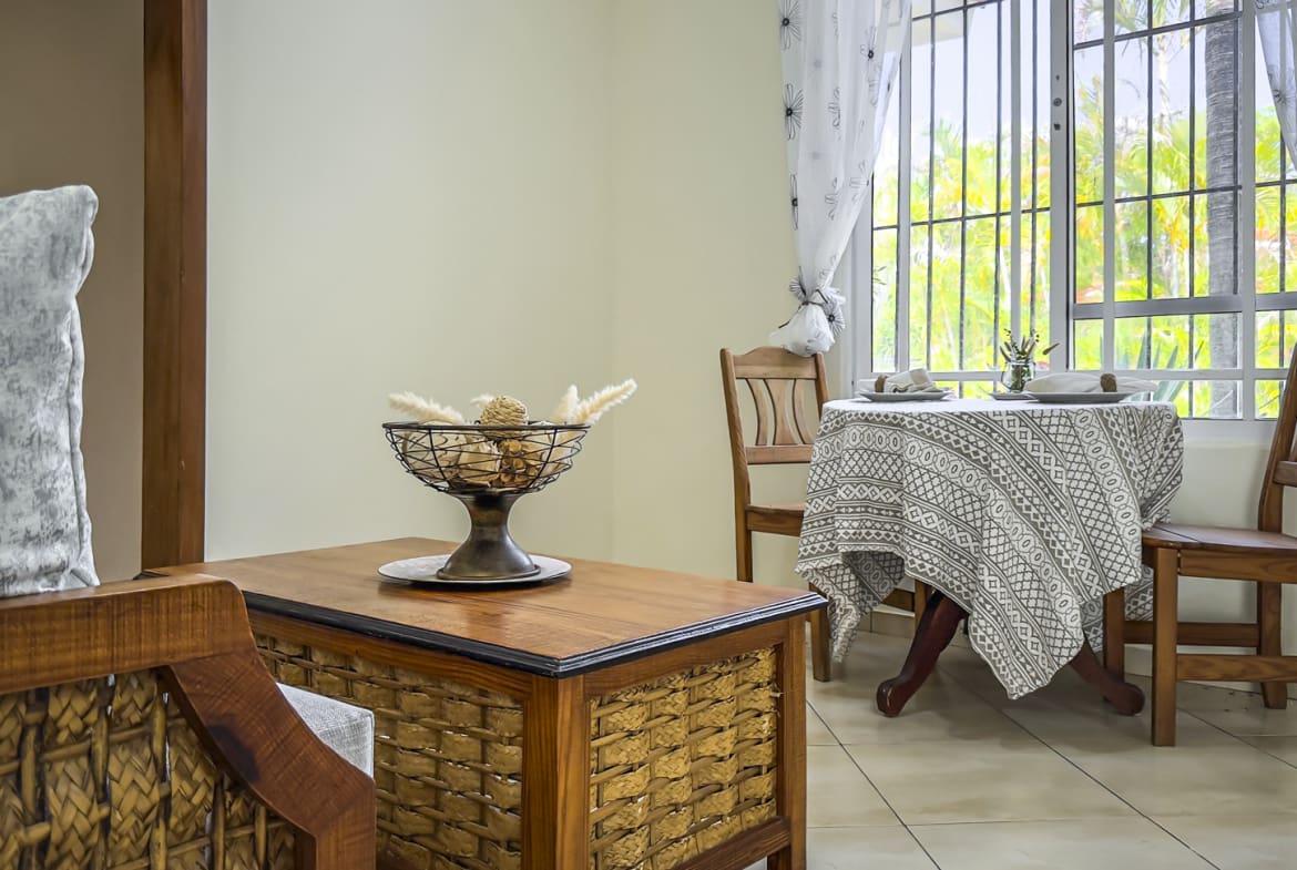 Cozy dining area with a wooden table, chairs, and a decorative bowl.