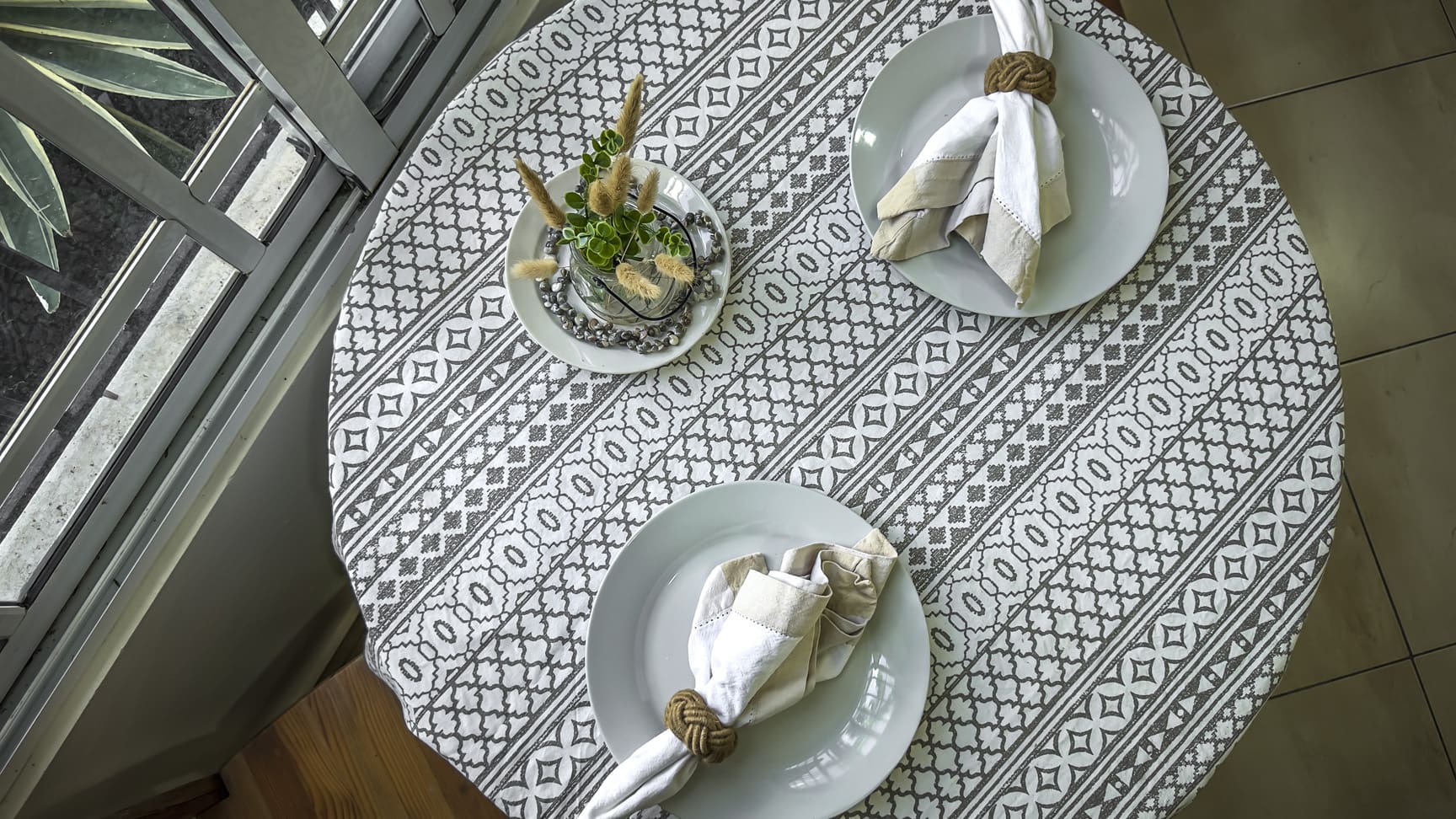 Table setting for two with white plates, napkins, and a centerpiece