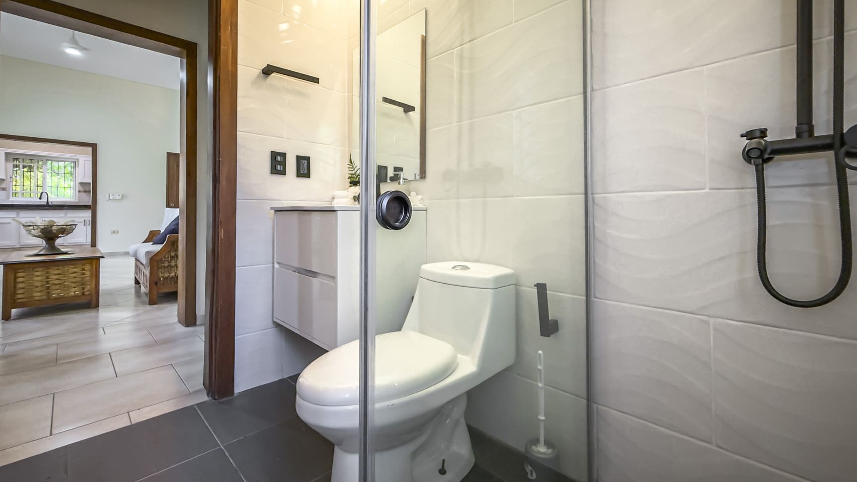 Modern bathroom with white toilet, glass shower, and sleek vanity
