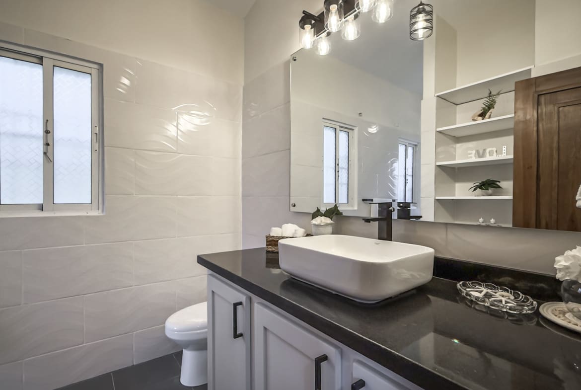 Modern white bathroom vanity with vessel sink and dark countertop