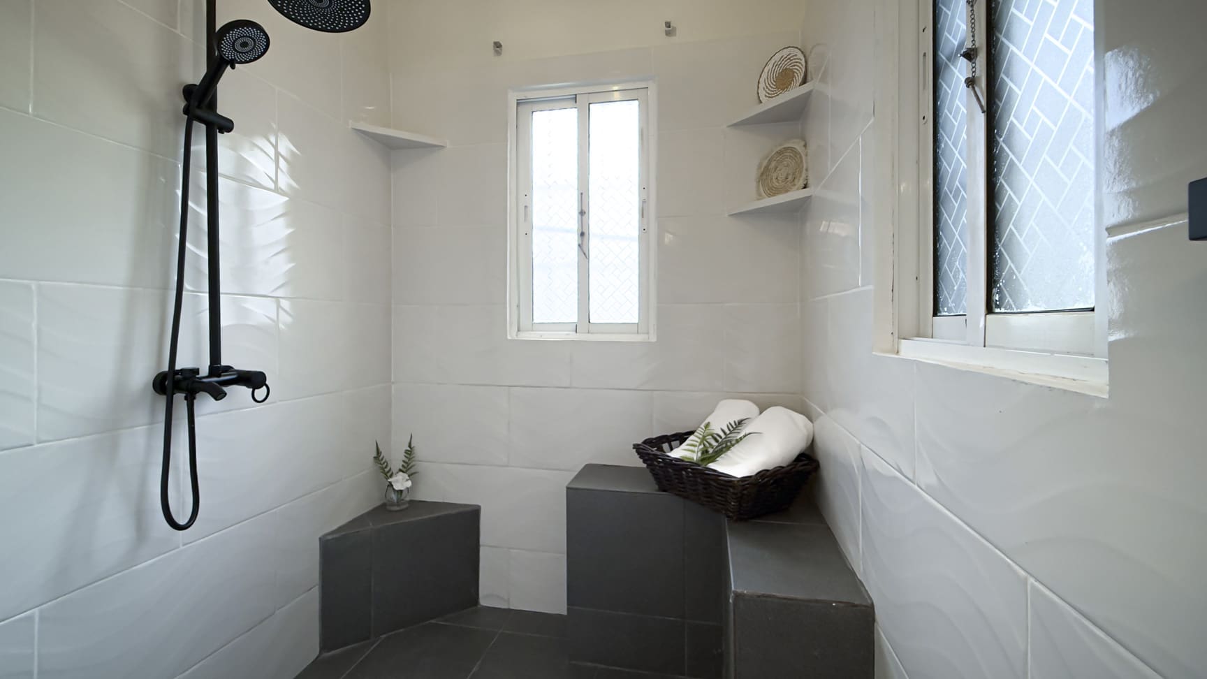 Modern white bathroom with black shower fixtures and a small window