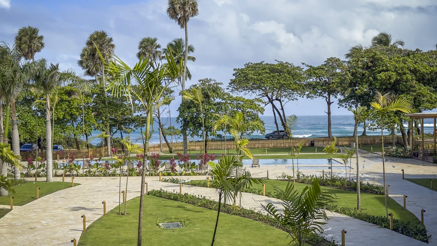 Tropical resort with palm trees, swimming pools, and ocean view