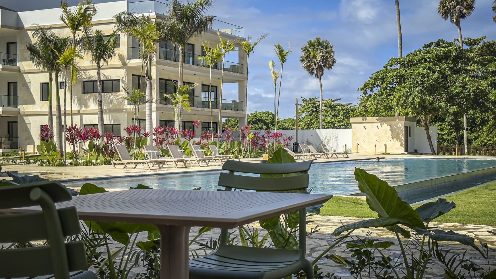 Modern resort pool with lounge chairs and tropical plants