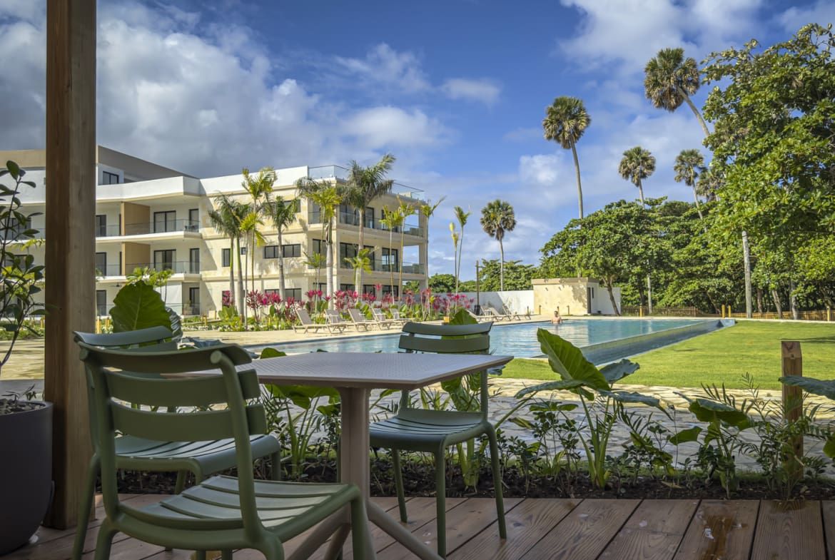 Modern resort with pool, palm trees, and tropical greenery