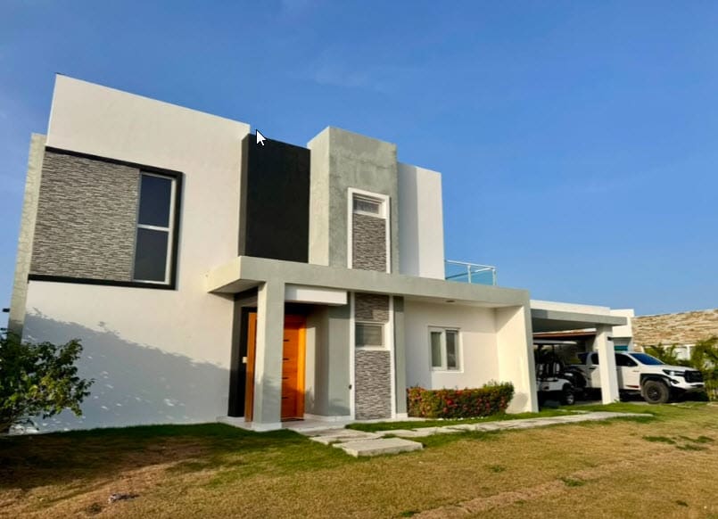 Modern white two-story house with orange door and covered parking