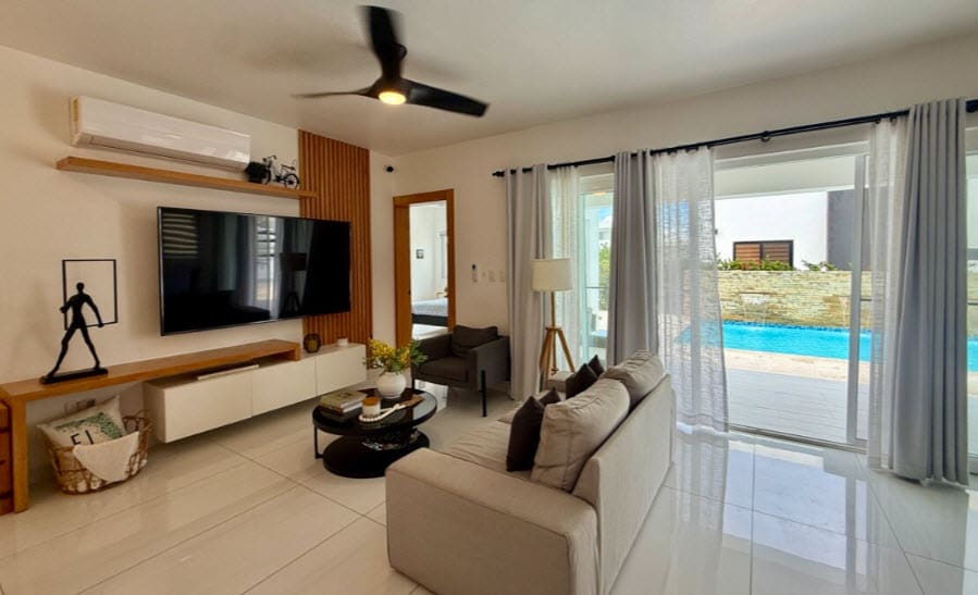 Modern living room with sofa, TV, and pool view
