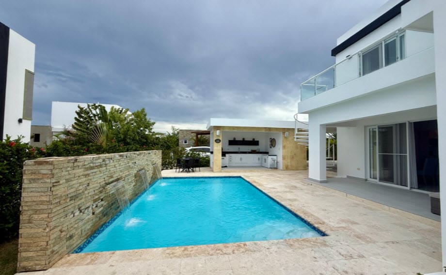 Modern villa with pool, outdoor kitchen, and waterfall feature