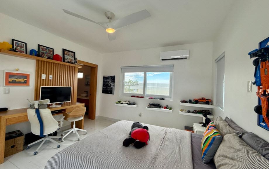 Modern bedroom with a desk, bed, and toy car collection