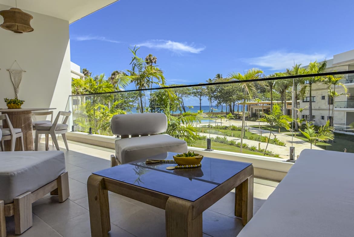 Balcony with modern furniture overlooking tropical resort and ocean view