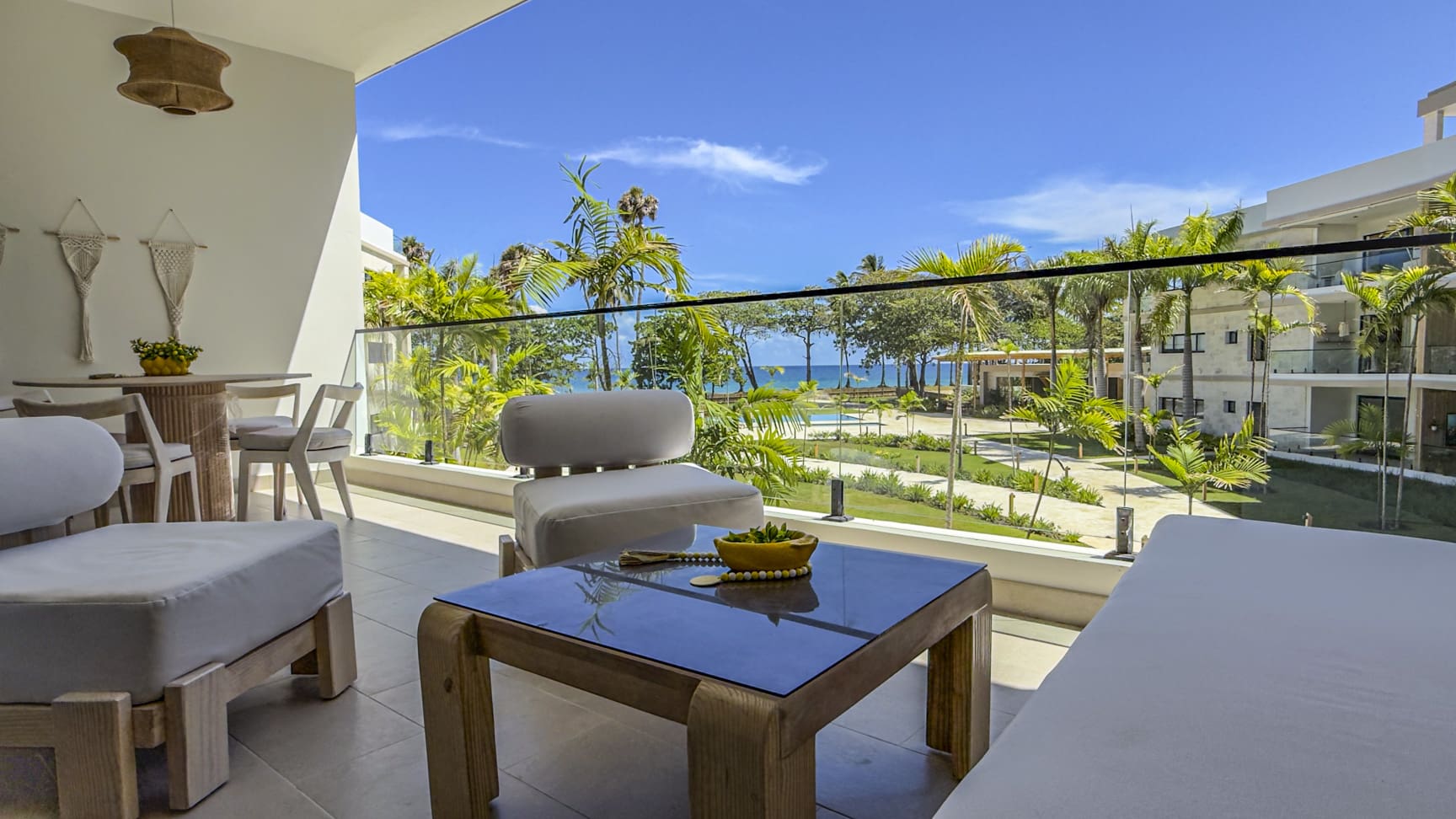 Balcony with modern furniture overlooking tropical resort and ocean view
