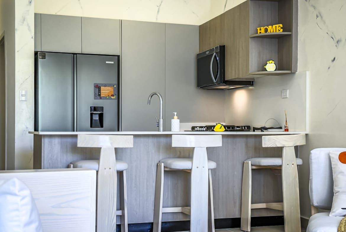 Modern kitchen with island, bar stools, and stainless steel refrigerator
