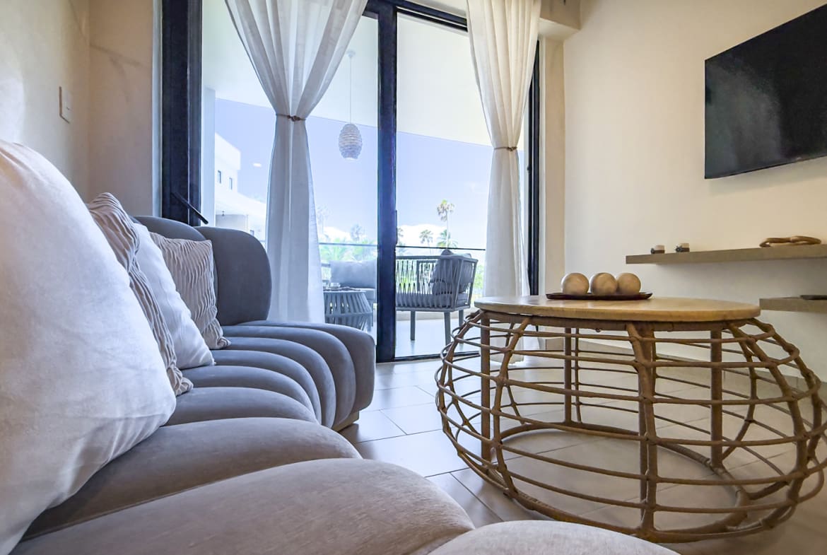 Modern living room with sofa, coffee table, and balcony view