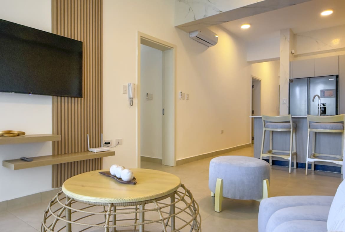 Modern living room with a TV, coffee table, and kitchen island