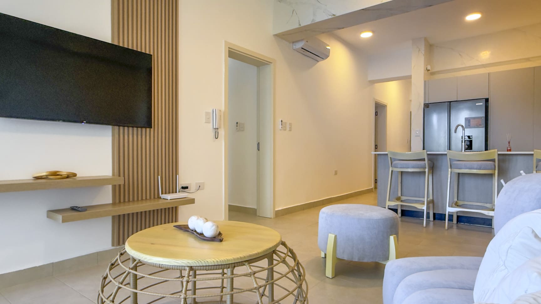 Modern living room with a TV, coffee table, and kitchen island