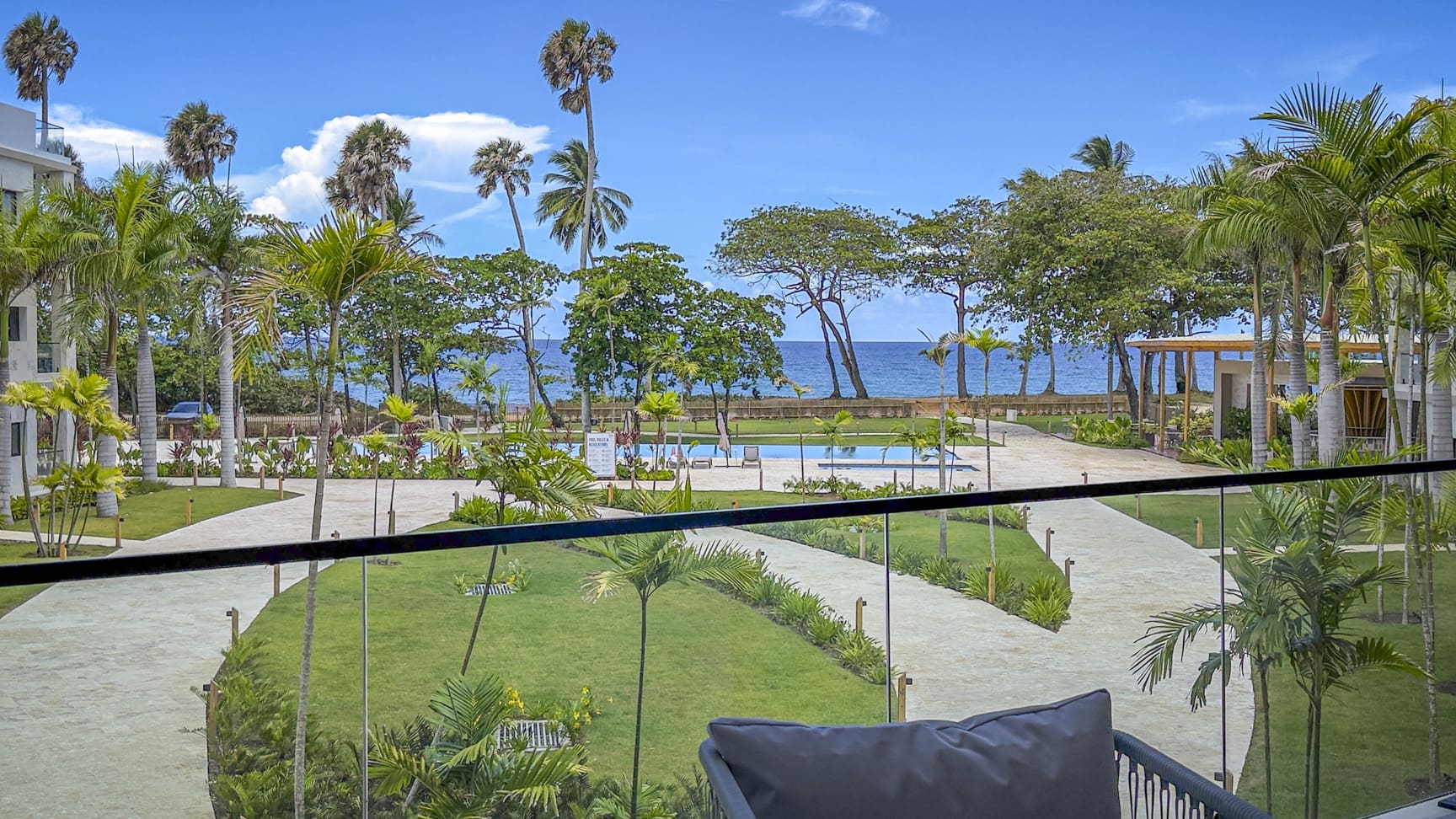 Tropical resort with palm trees, pool, and ocean view