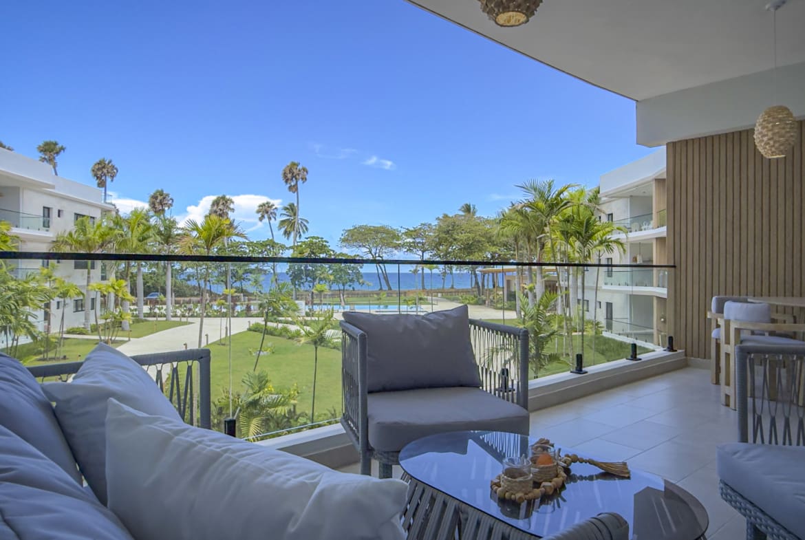 Luxury balcony with ocean view, palm trees, and modern furniture