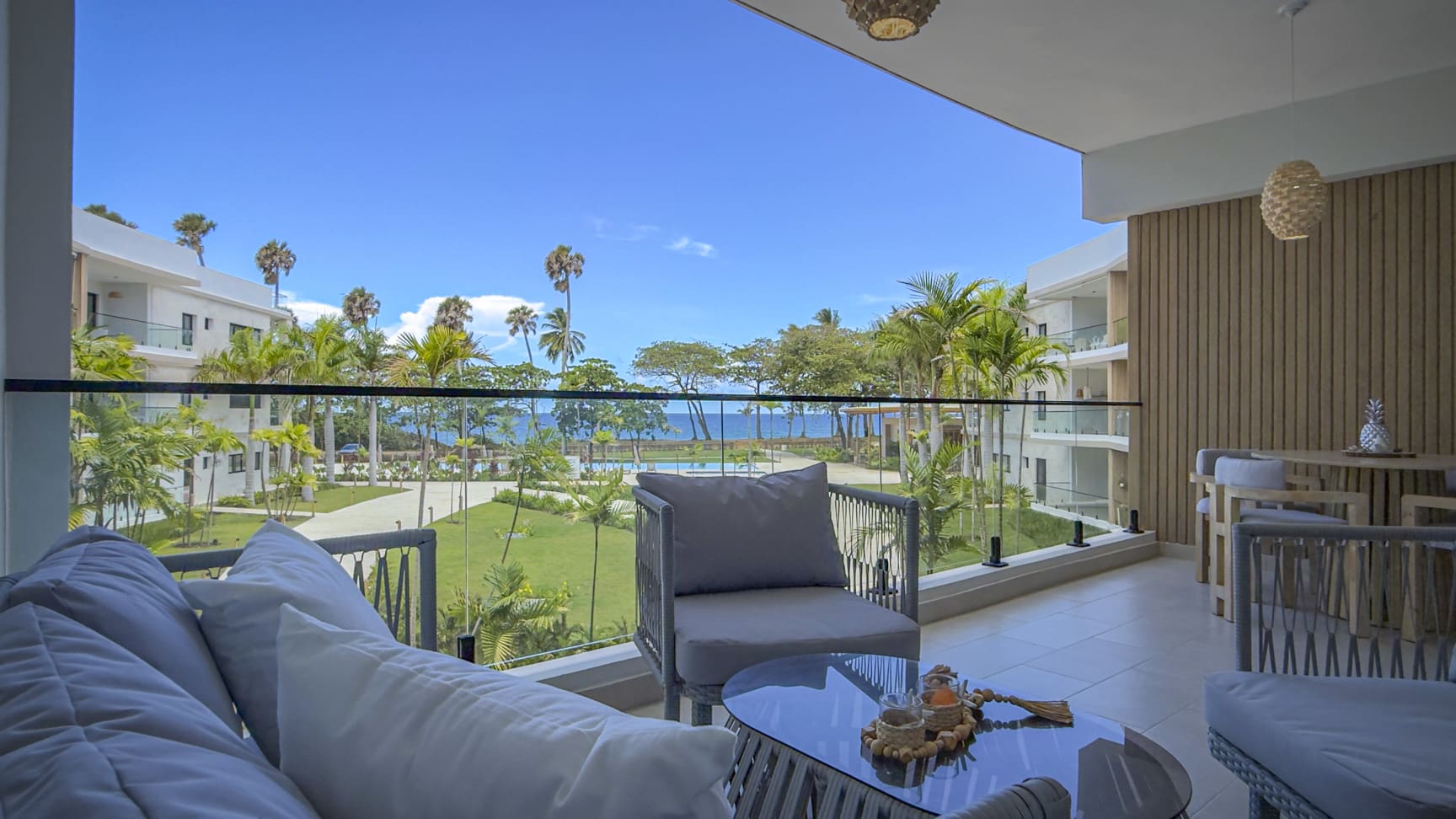 Luxury balcony with ocean view, palm trees, and modern furniture