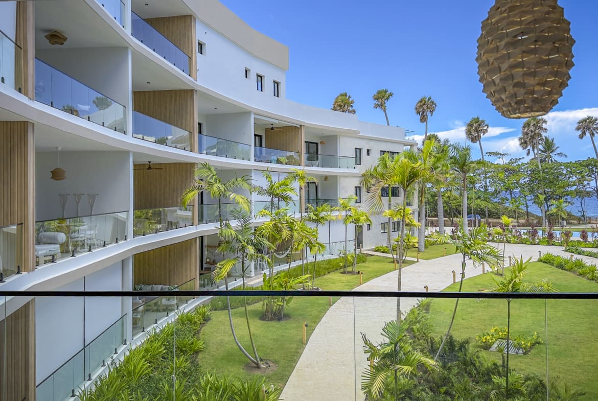Modern resort balconies overlooking a tropical garden and ocean view