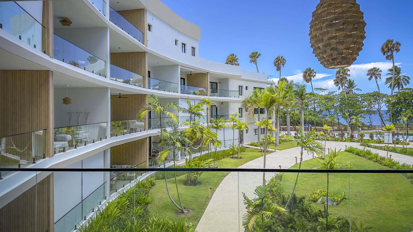 Modern resort balconies overlooking a tropical garden and ocean view