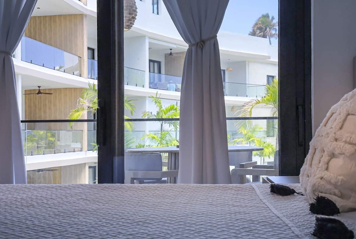 Modern hotel room balcony with ocean view and white curtains