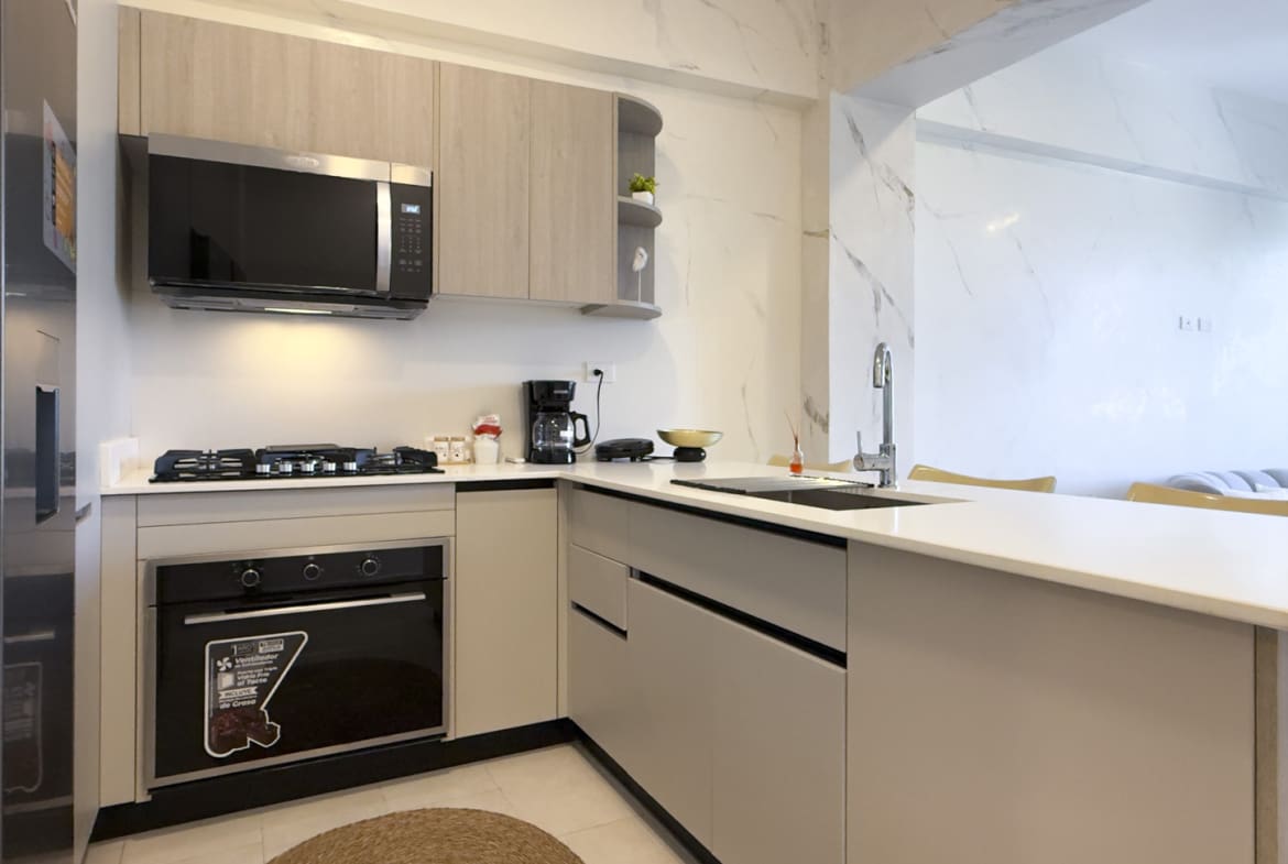 Modern kitchen with stainless steel appliances, gas stove, and marble accents.