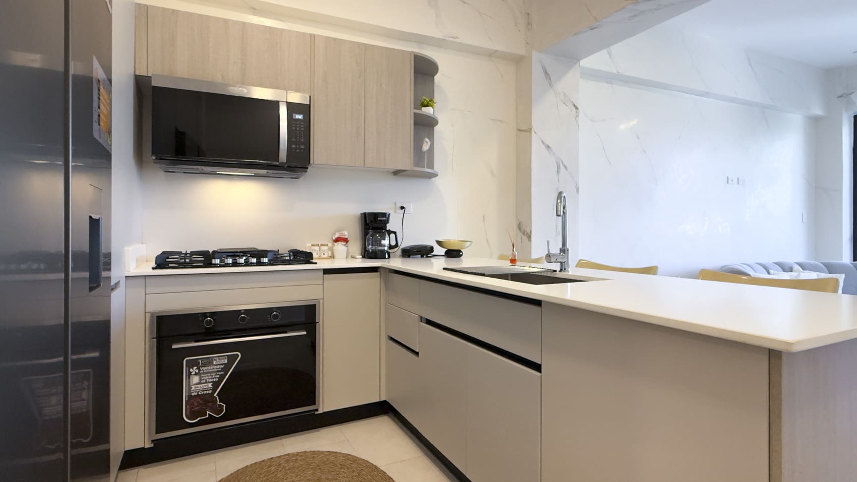 Modern kitchen with stainless steel appliances, gas stove, and marble accents.
