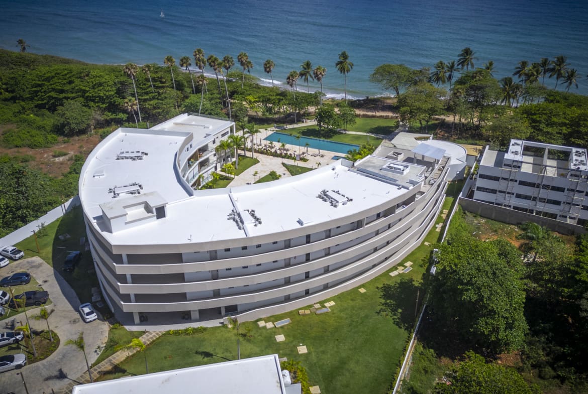 Curved modern resort buildings with pool and ocean views