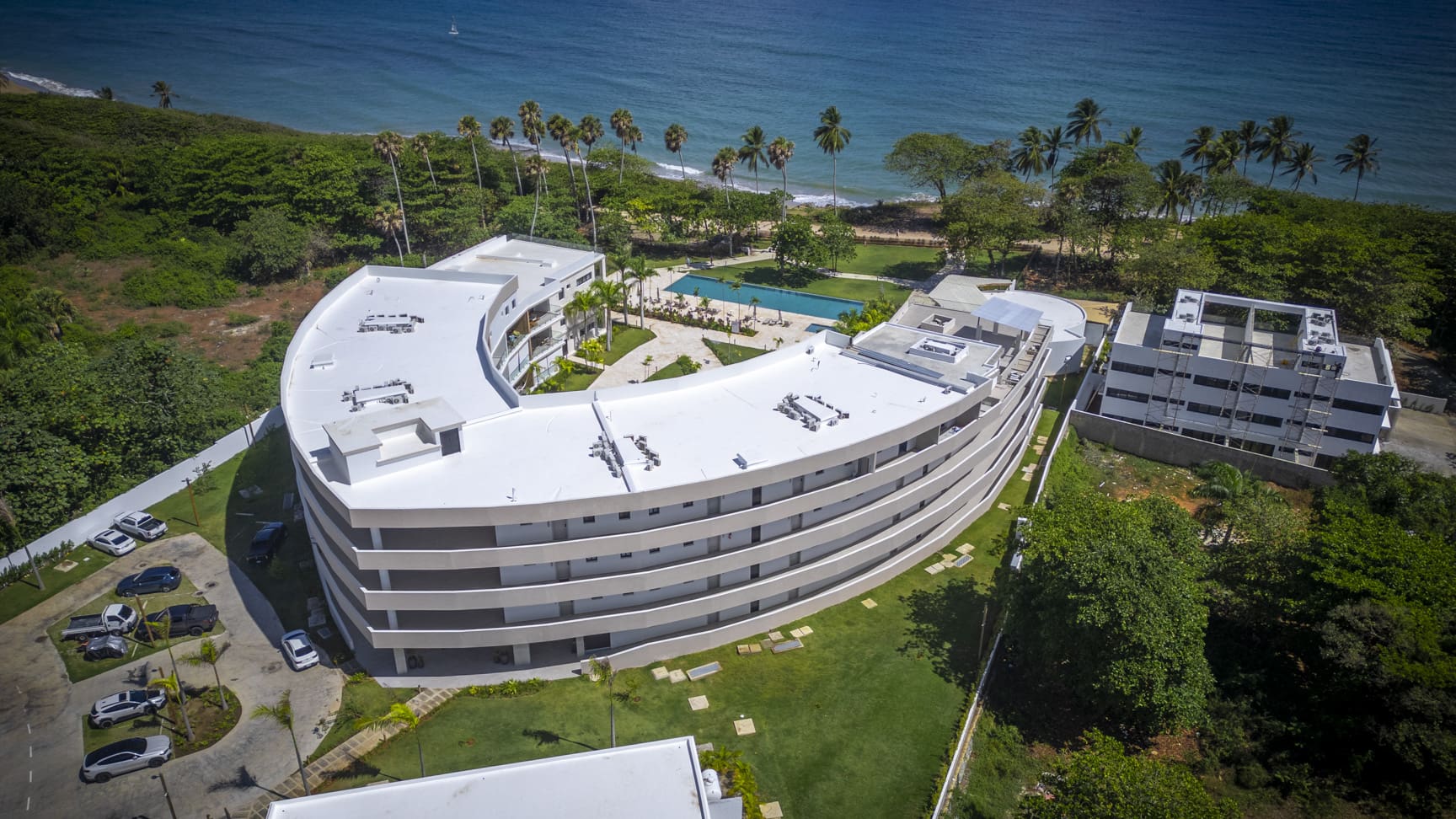 Curved modern resort buildings with pool and ocean views