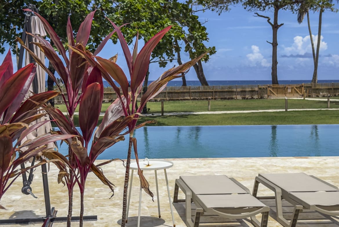 Tropical resort poolside with lounge chairs and ocean view