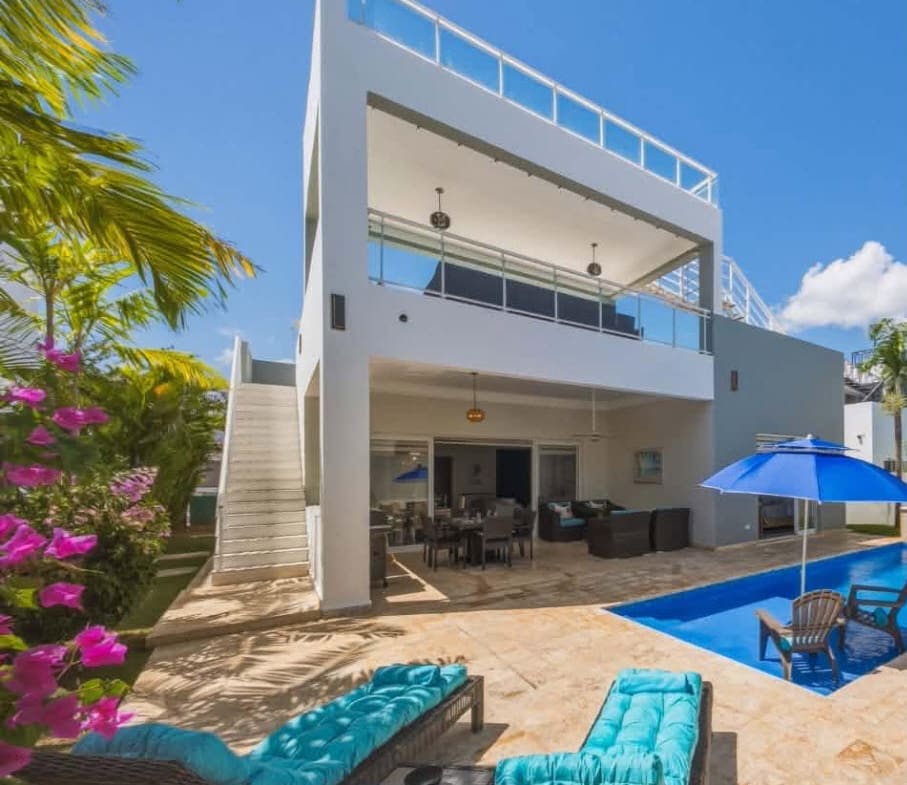Luxury villa with private pool and lounge chairs in a tropical setting.