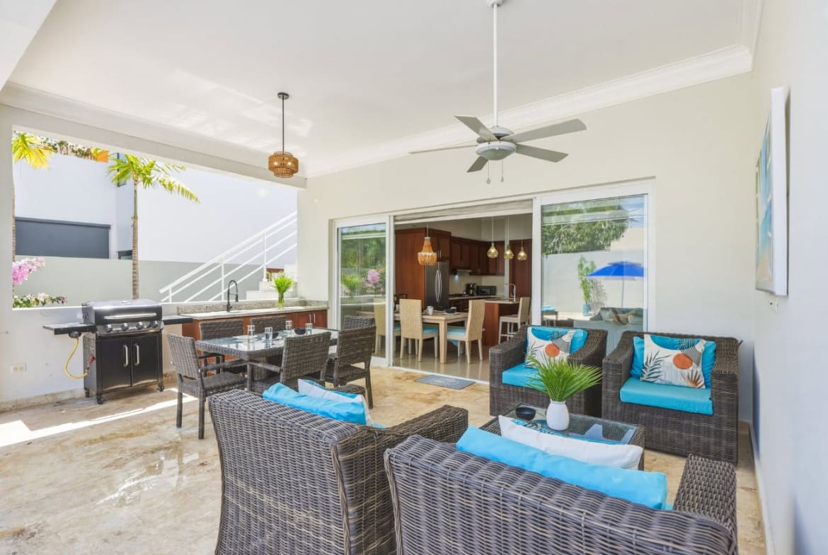 Outdoor patio with dining table, seating area, and kitchen