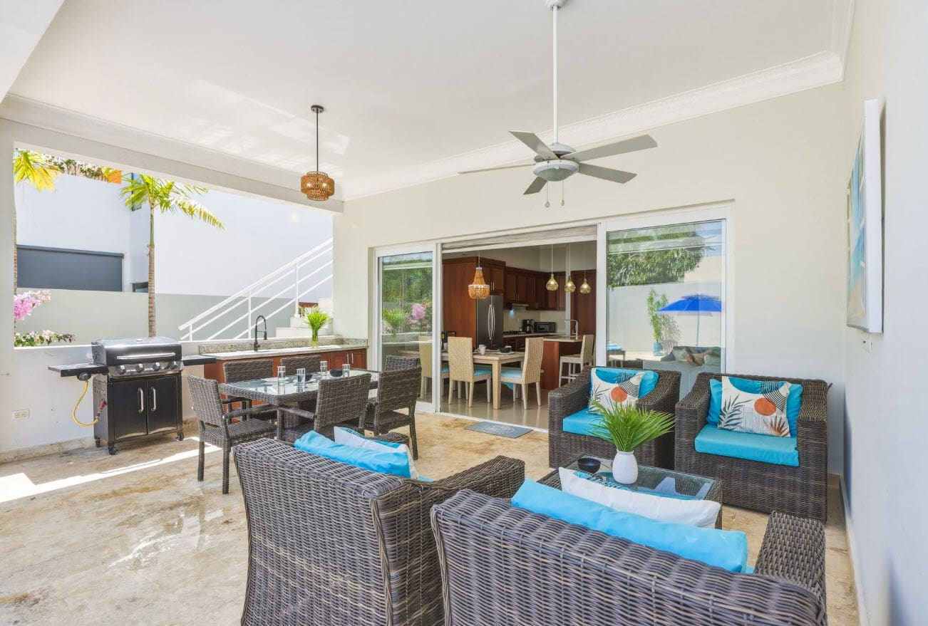 Outdoor patio with dining table, seating area, and kitchen