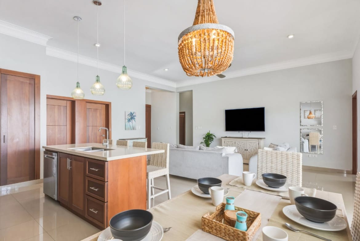 Modern dining area and kitchen island with pendant lights and seating.