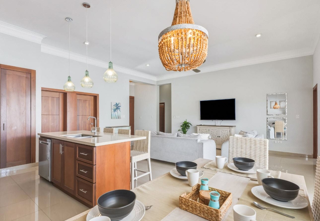 Modern dining area and kitchen island with pendant lights and seating.