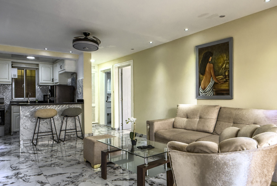 Modern living room and kitchen with plush seating and marble floors