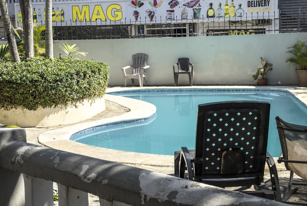 Outdoor swimming pool with lounge chairs and lush greenery