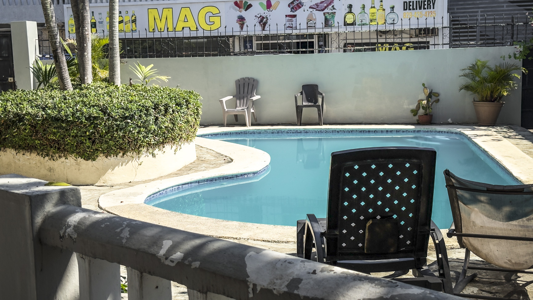 Outdoor swimming pool with lounge chairs and lush greenery