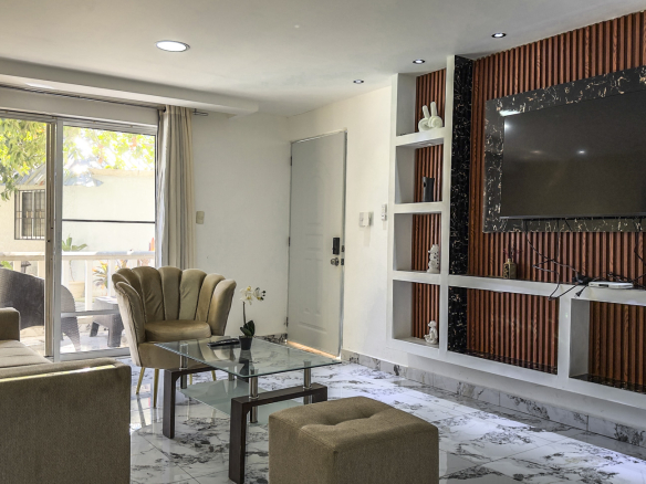 Modern living room with plush seating, glass coffee table, and wall-mounted TV