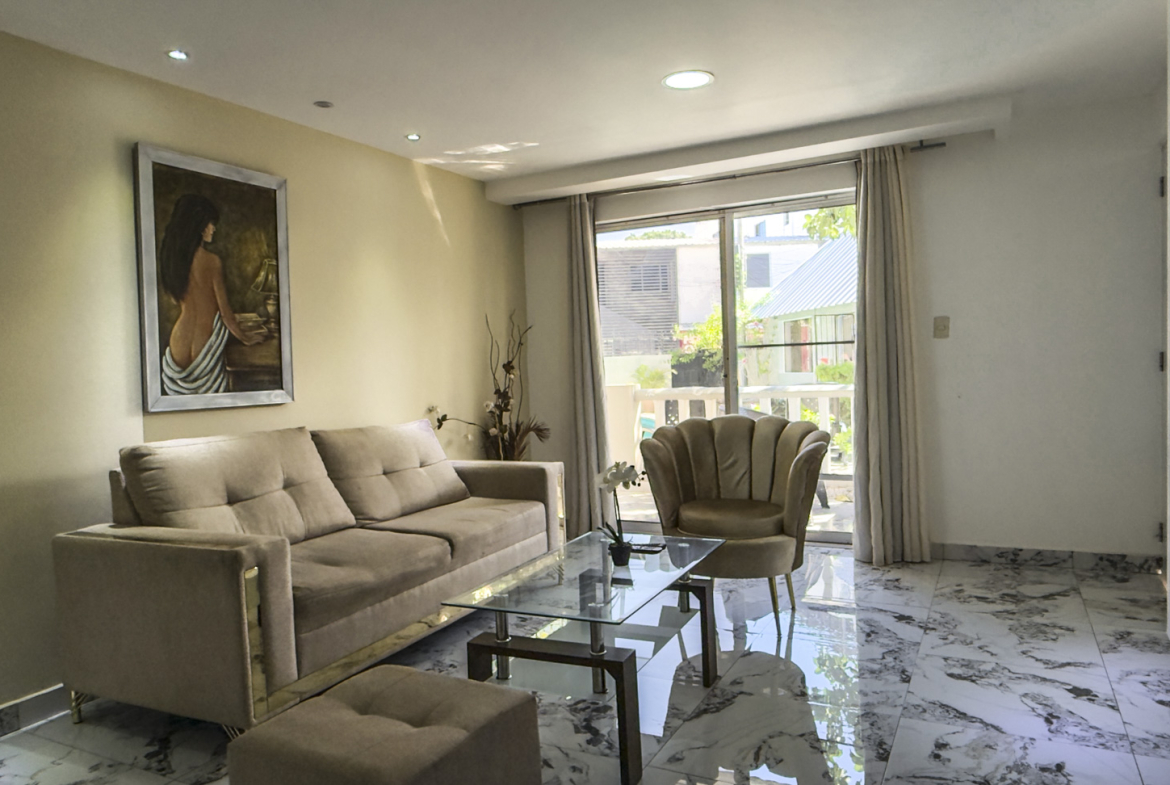 Modern living room with beige sofa, glass coffee table, and art