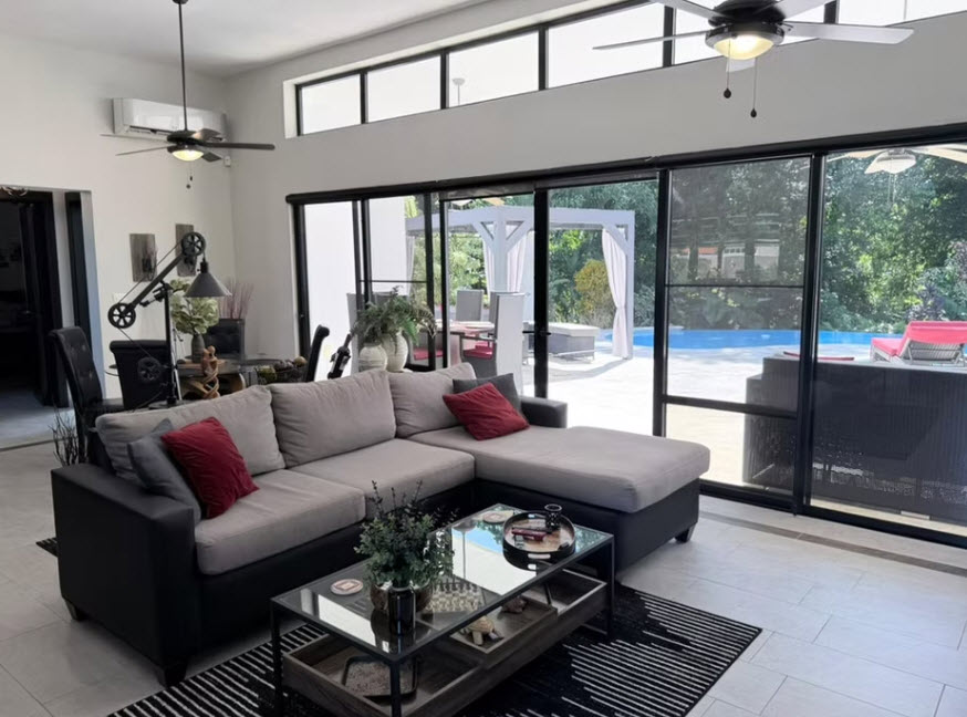 Modern living room with sectional sofa, coffee table, and pool view