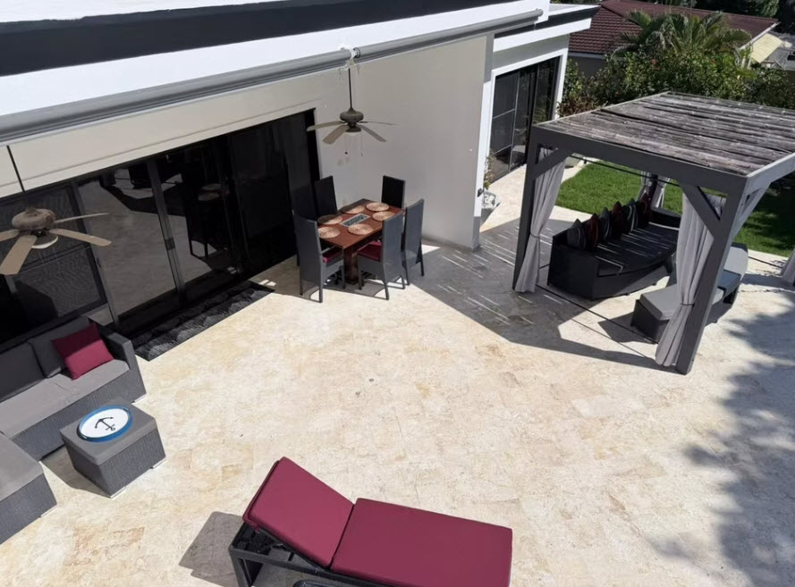 Modern patio with outdoor dining set, lounge chairs, and pergola.