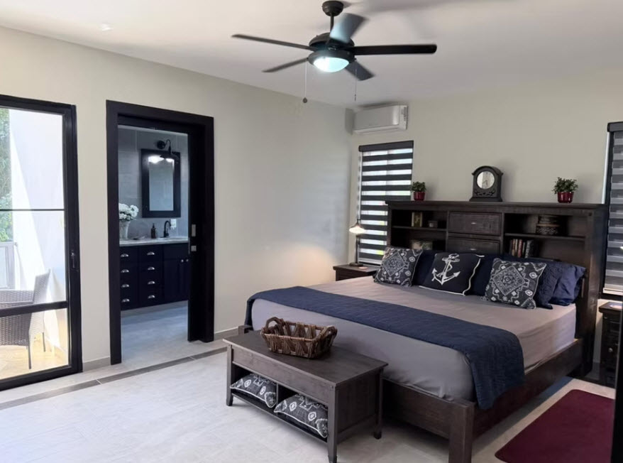 Modern bedroom with king-size bed, nautical decor, and en-suite bathroom view