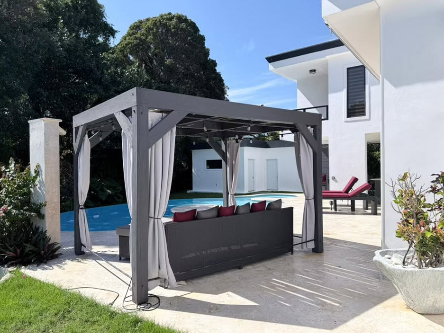 Modern grey pergola with outdoor sofa by pool at luxury home
