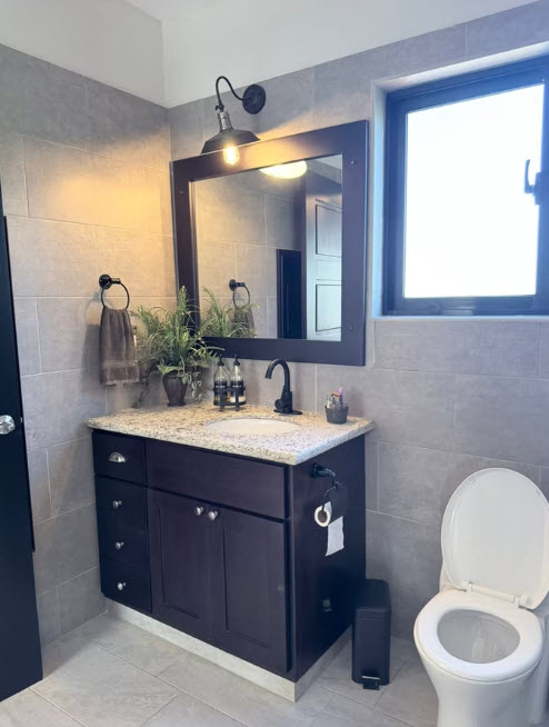 Modern bathroom vanity with granite countertop and subway tile walls
