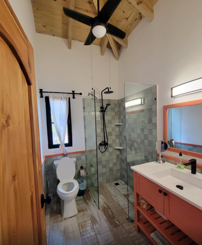 Modern bathroom with walk-in shower, wood accents, and orange vanity.