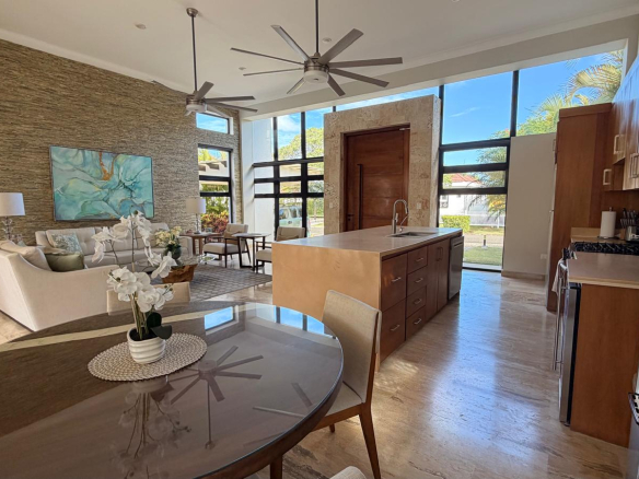 Modern open-plan living and kitchen area with large windows and island